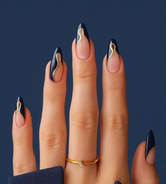 Foto de referência: unhas amendoadas azul-marinho com traço dourado